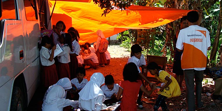 Students learning outside because their school was destroyed